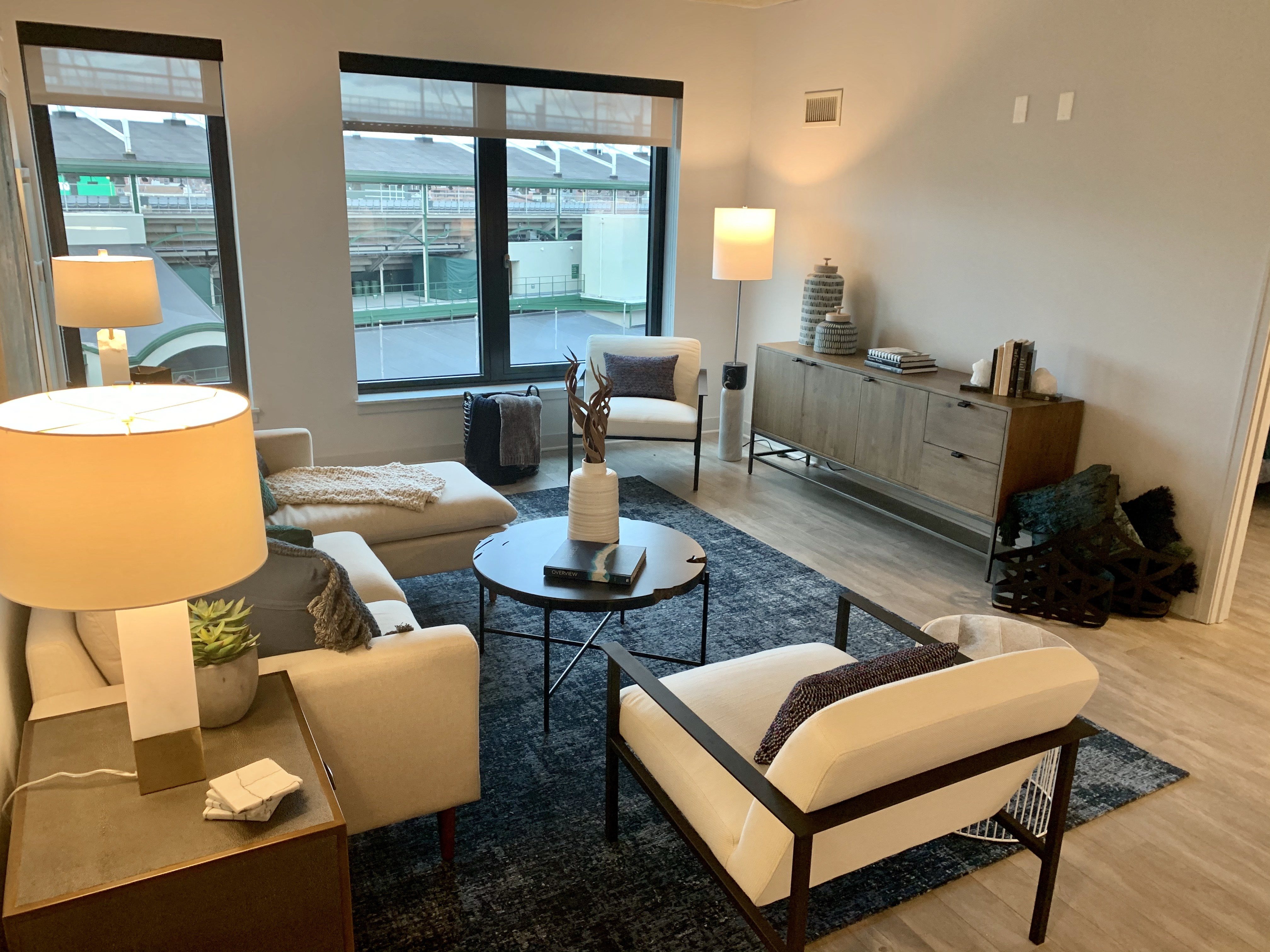 a living room with white furniture and a large window at Residences at Addison Clark Apartments, IL, 60613
