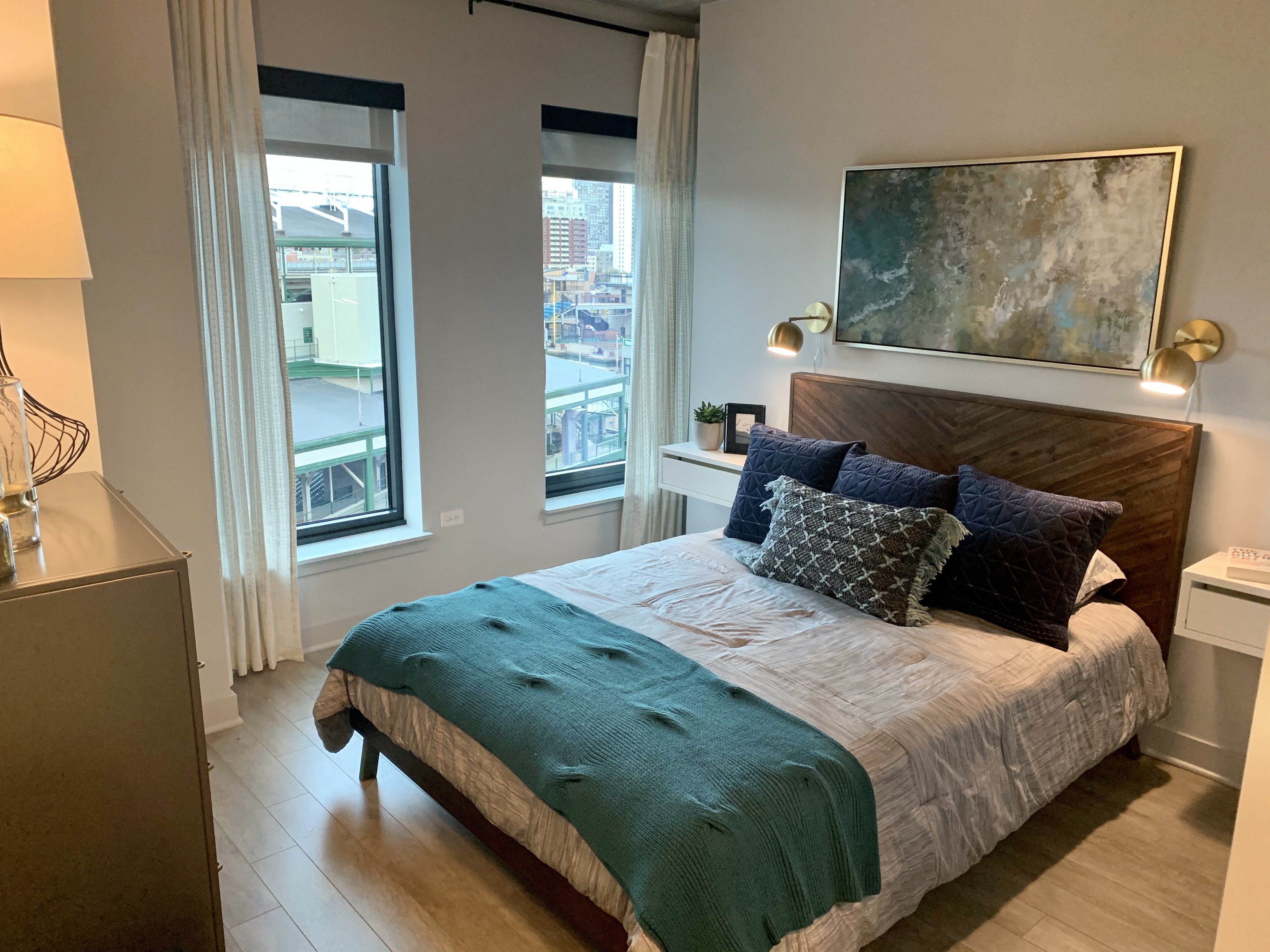 a bedroom with a bed and a large window at Residences at Addison Clark Apartments, Chicago, IL, 60613