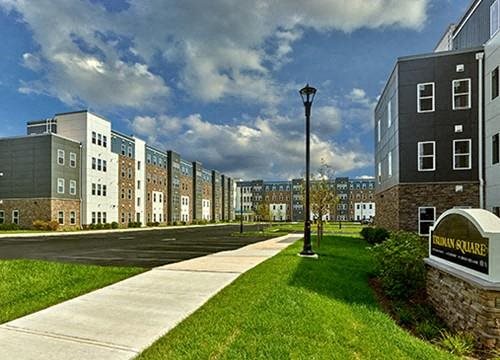 a row of apartment buildings on the side of a sidewalk