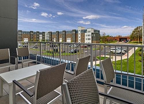 a patio with chairs and tables on a balcony
