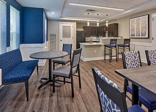 a dining room with tables and chairs and a kitchen