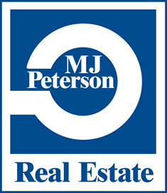A blue and white logo for MJ Peterson Real Estate.
