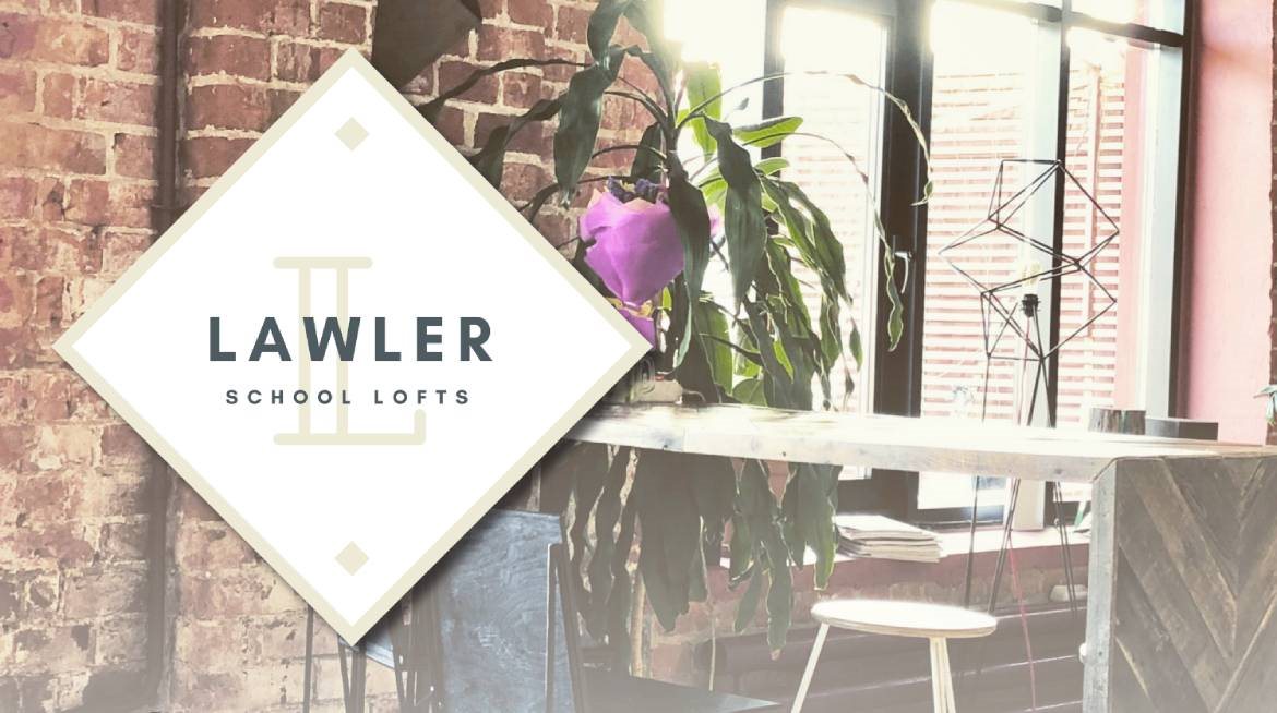 A white sign with the words Lawler School Lofts on it.