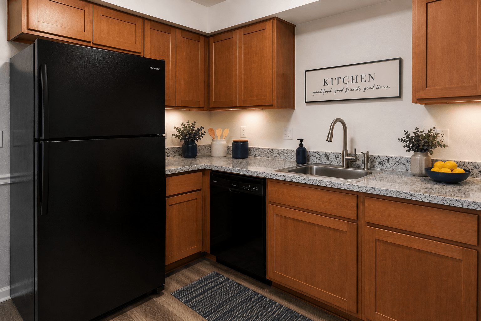 A black refrigerator sits in a kitchen with wooden cabinets and a marble countertop.