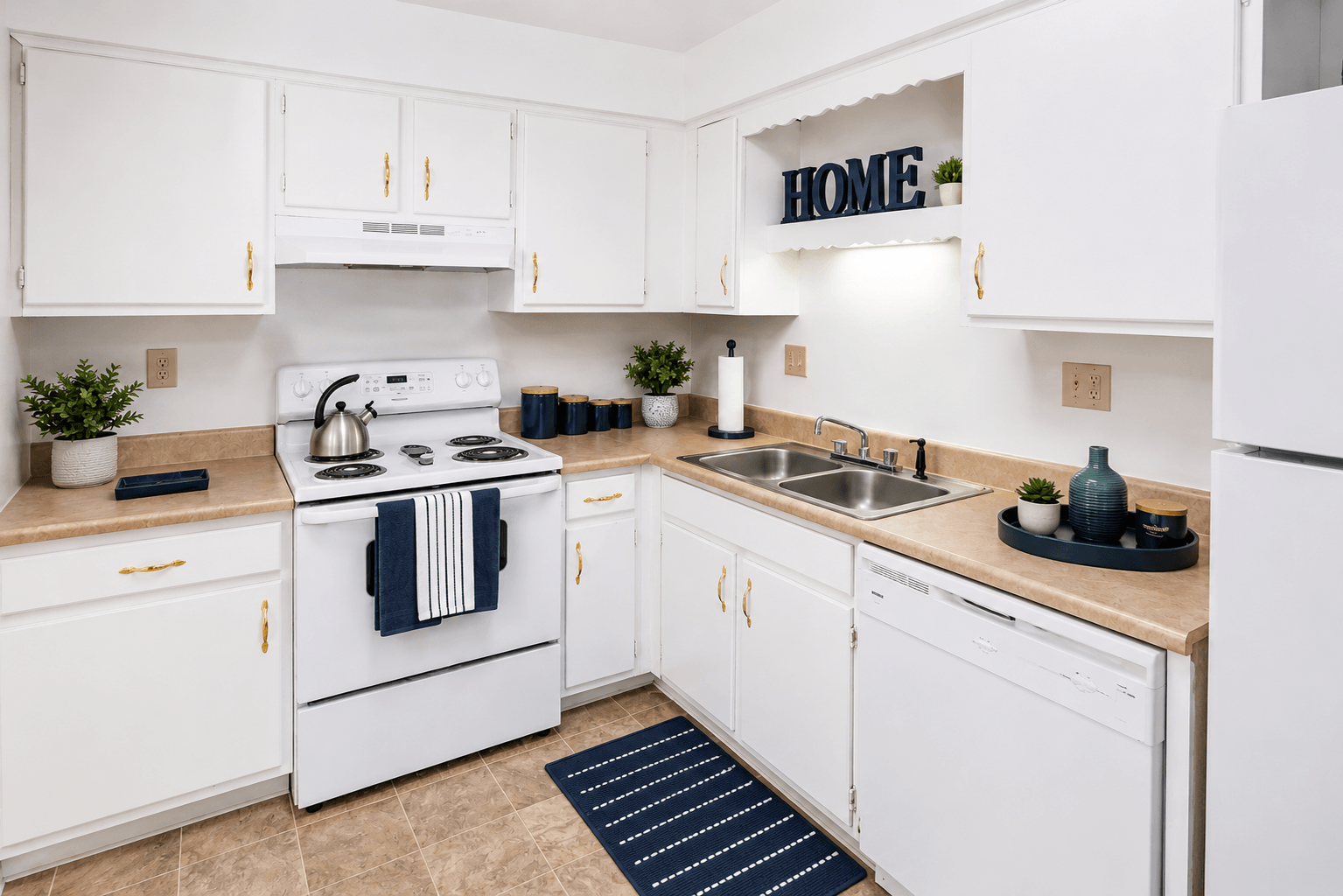 A white kitchen with a sign that says "HOME" on the wall.