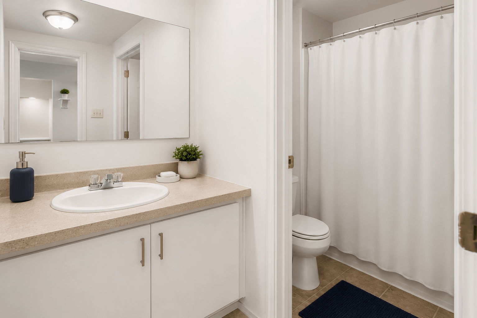 A bathroom with a white sink, toilet, and shower curtain.