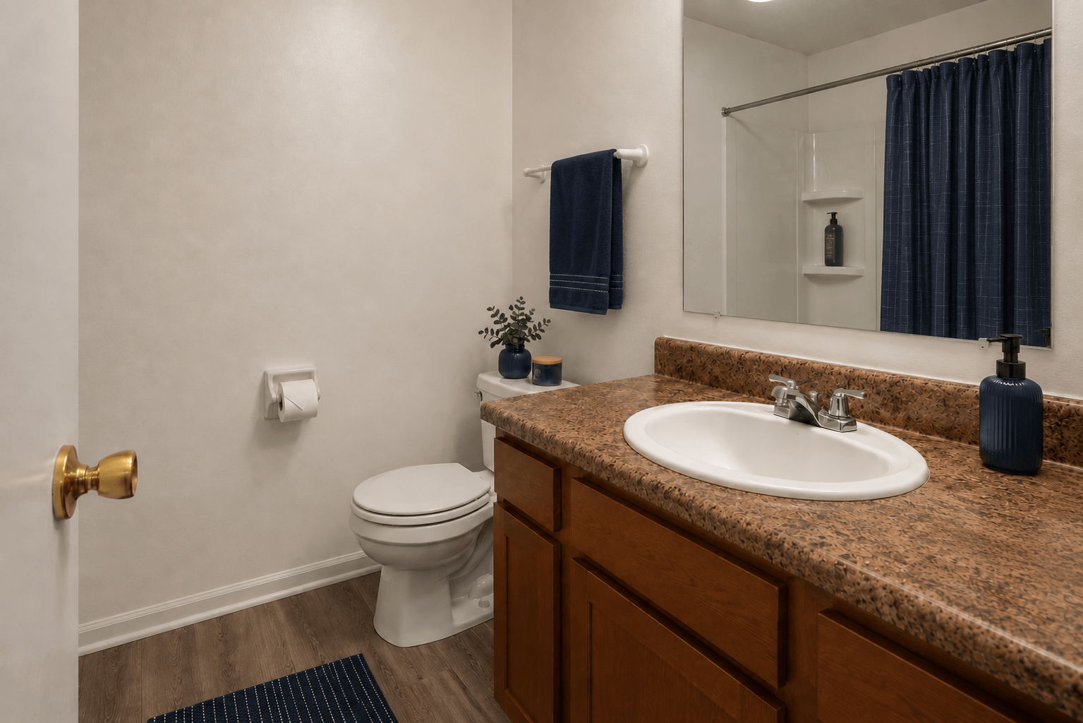 A bathroom with a toilet, sink, and mirror.