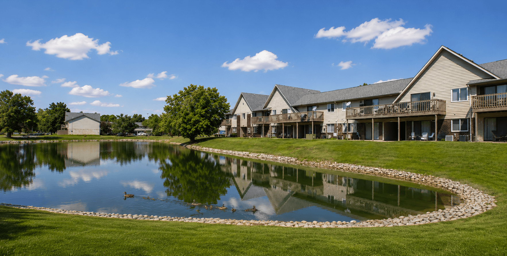 A lake in front of a building with a clear blue sky.,A lake in front of a building with a clear blue sky.
