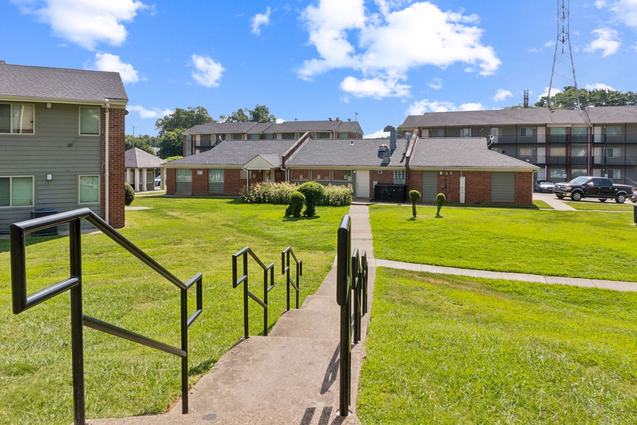 A view of a residential area with houses and a grassy area.