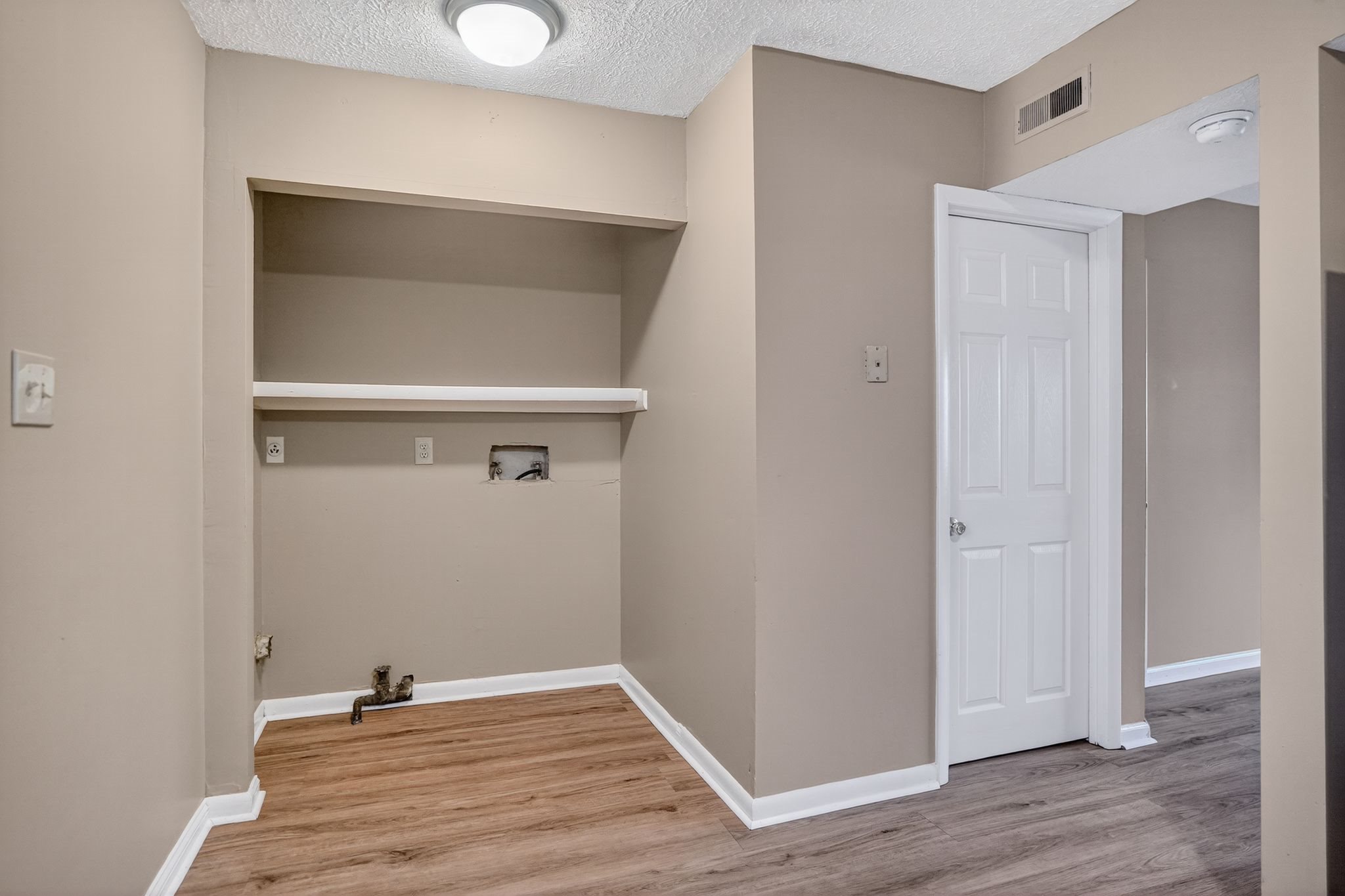 A room with a white door and a built in shelf.