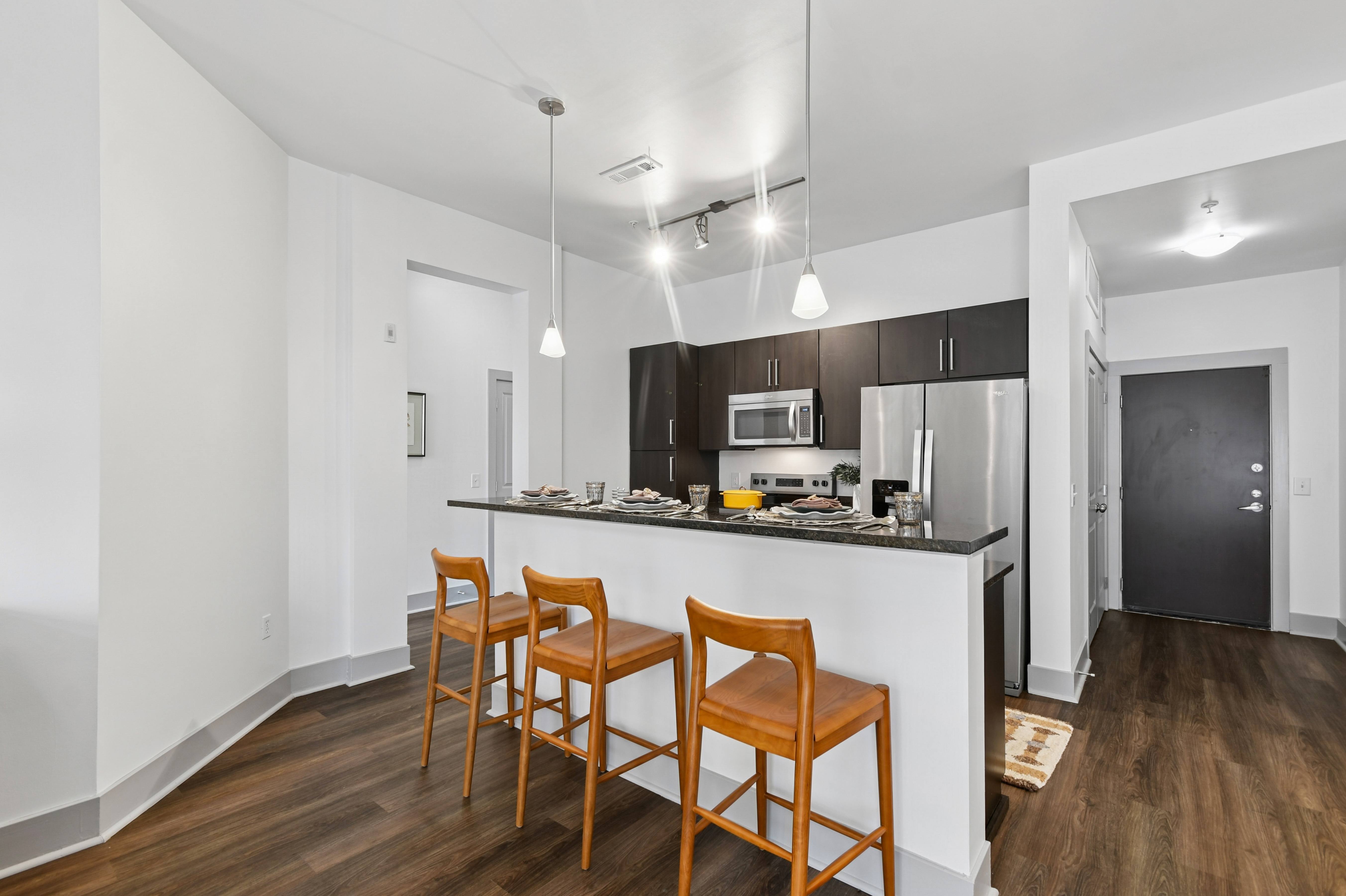 A kitchen with a bar area and two chairs.