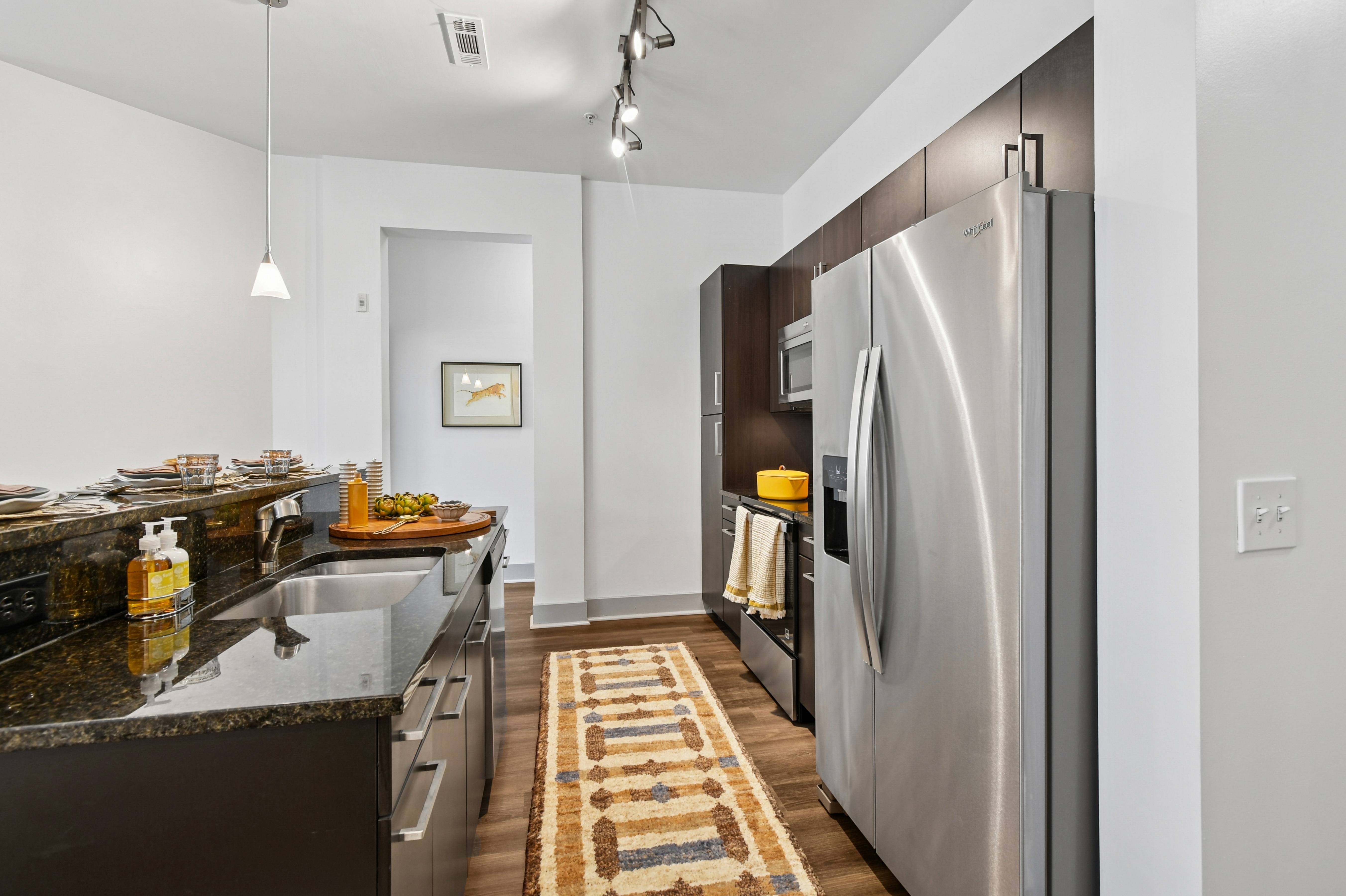 A modern kitchen with a refrigerator, sink, and countertop.