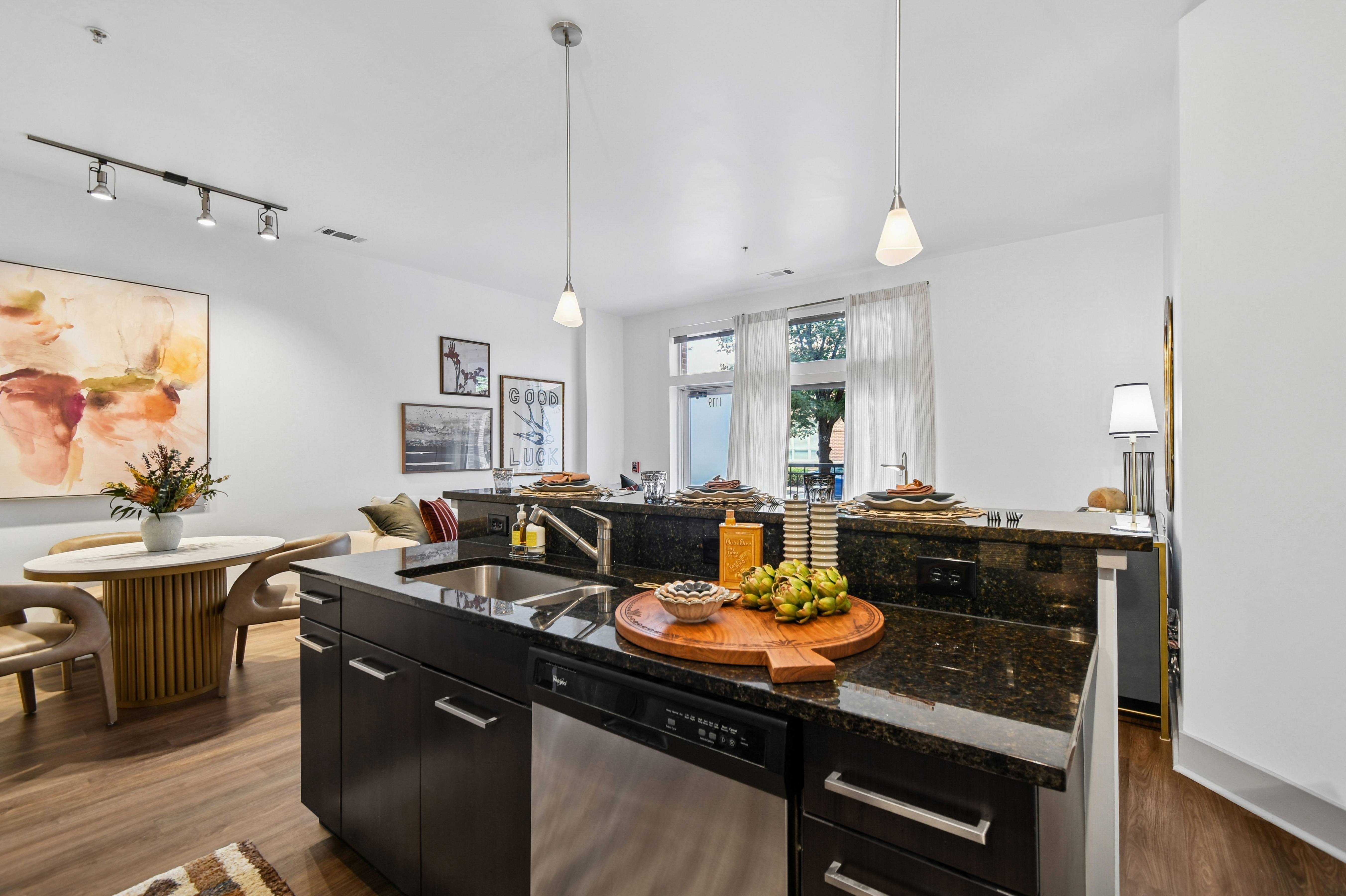 A modern kitchen with black appliances and a wooden table.