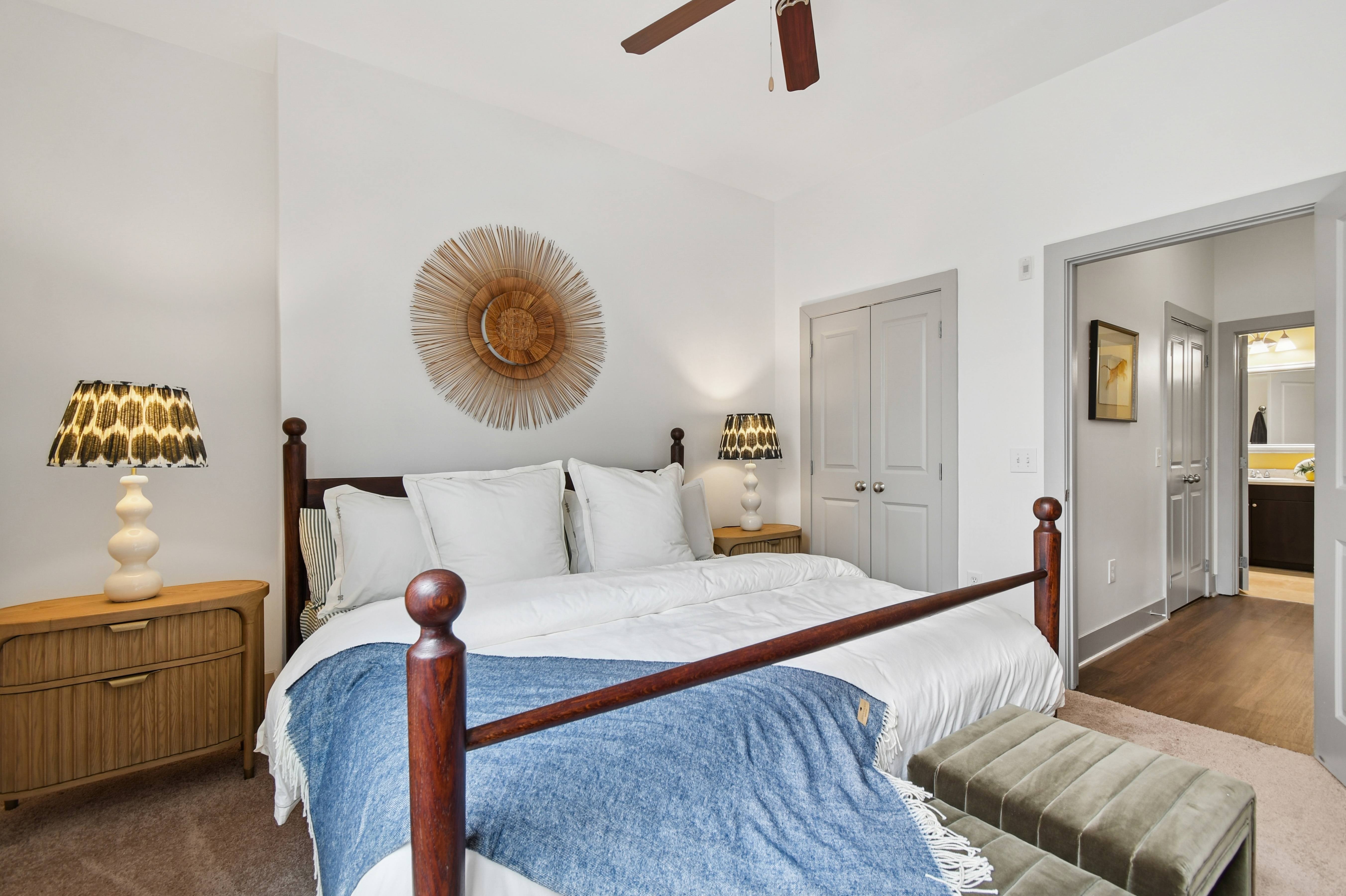 A bedroom with a bed, nightstand, and a ceiling fan.