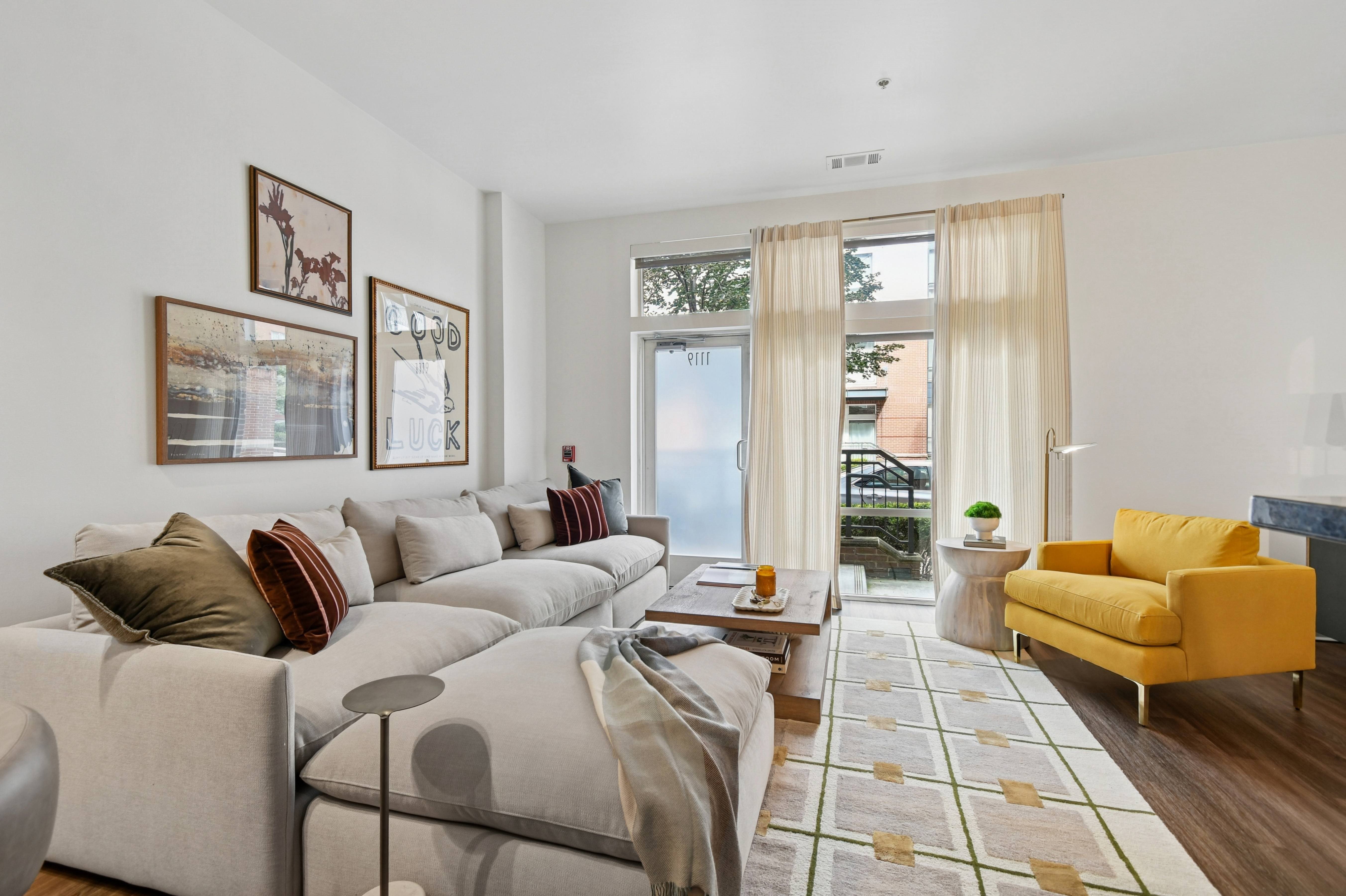 A living room with a grey couch, a yellow chair, and a coffee table.