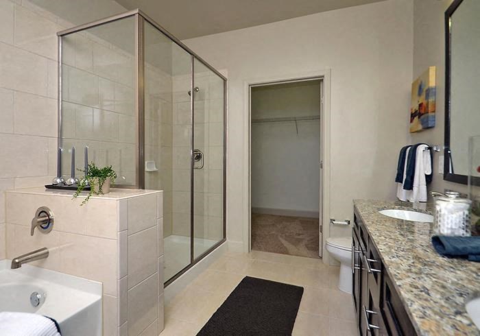 a bathroom with a glass shower stall and a sink