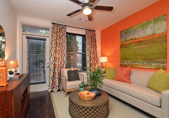 a living room with an orange wall and a white couch