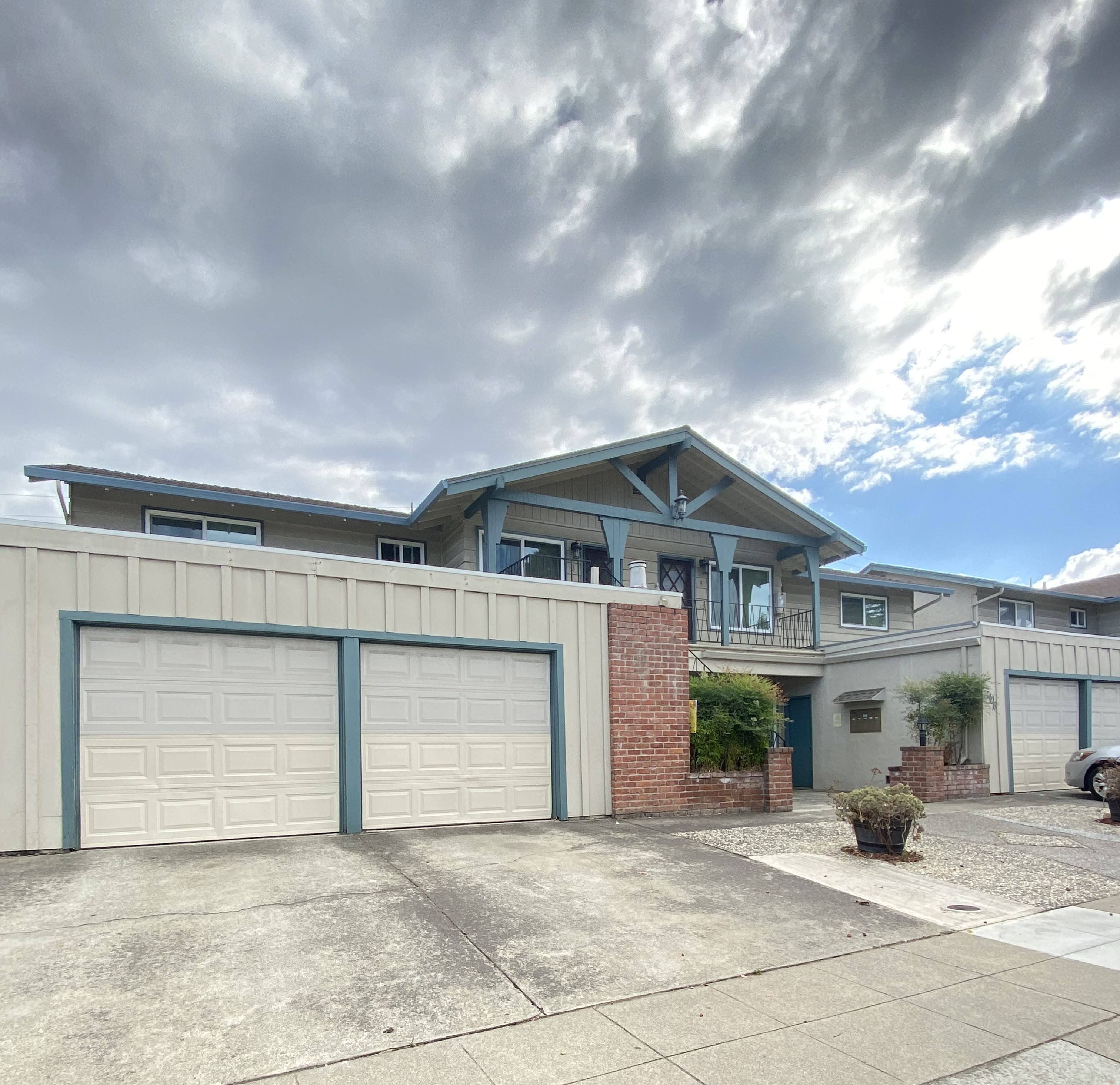 A two-story house with a garage and a driveway.