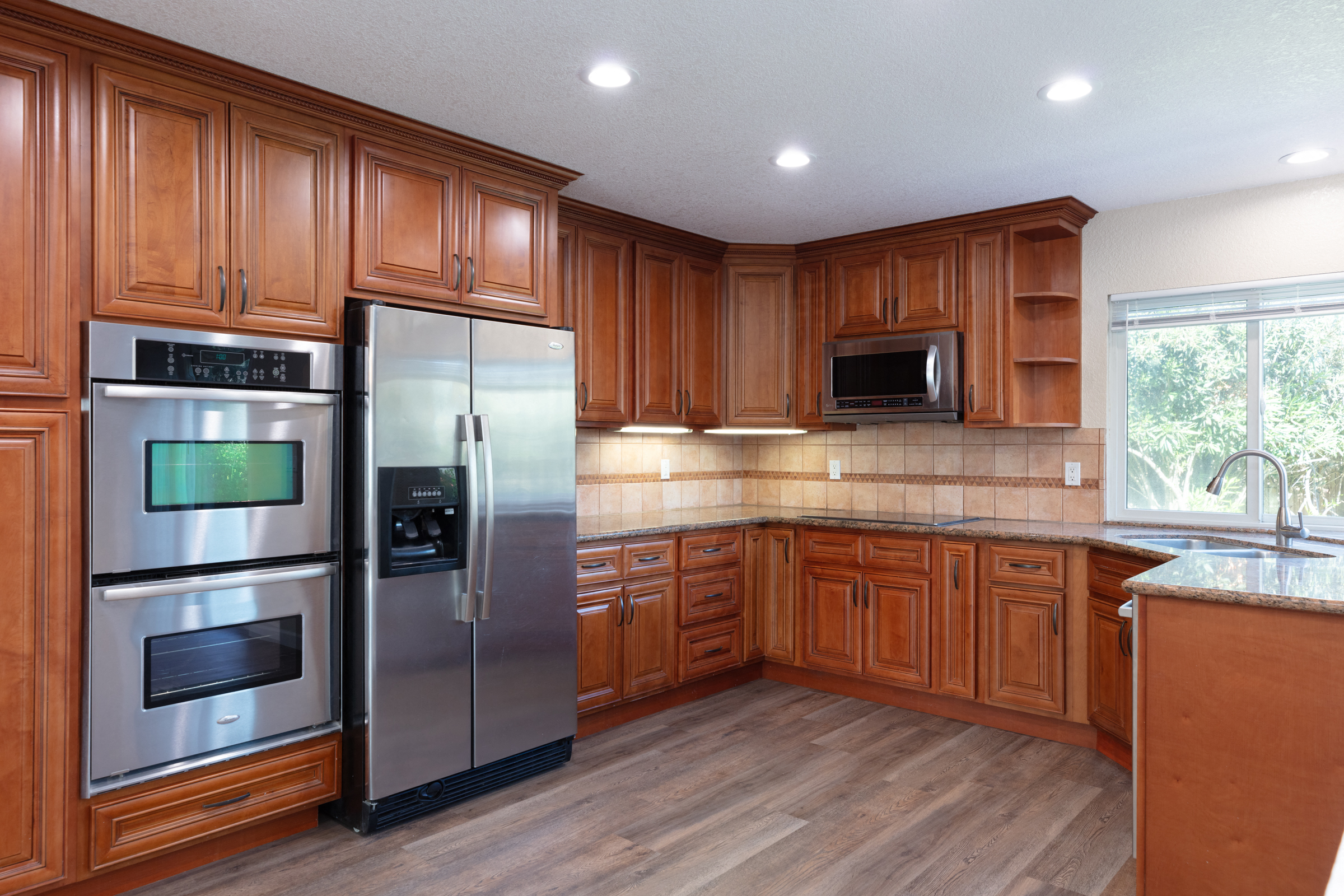 wood cabinets in kitchen with stainless steel appliances
