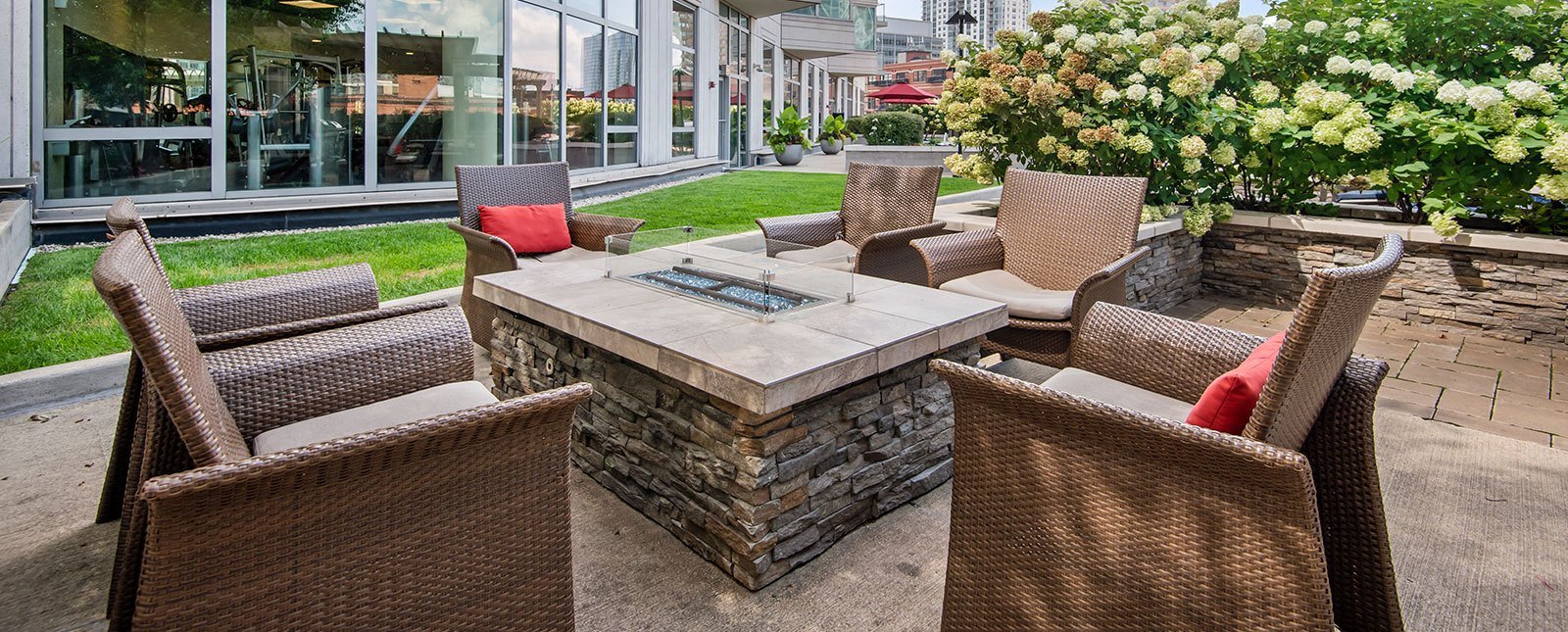 Spacious, landscaped outdoor terrace with lush seating, grills and a fire pit