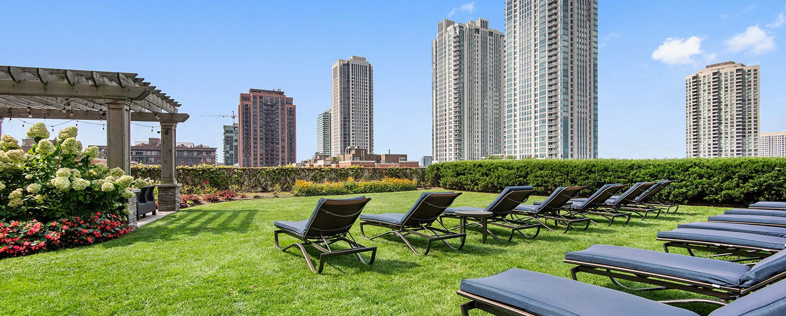 Spacious, landscaped outdoor terrace with lush seating, grills and a fire pit