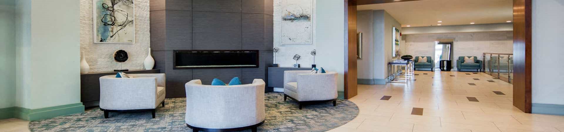 a lobby with chairs and a television in a hotel