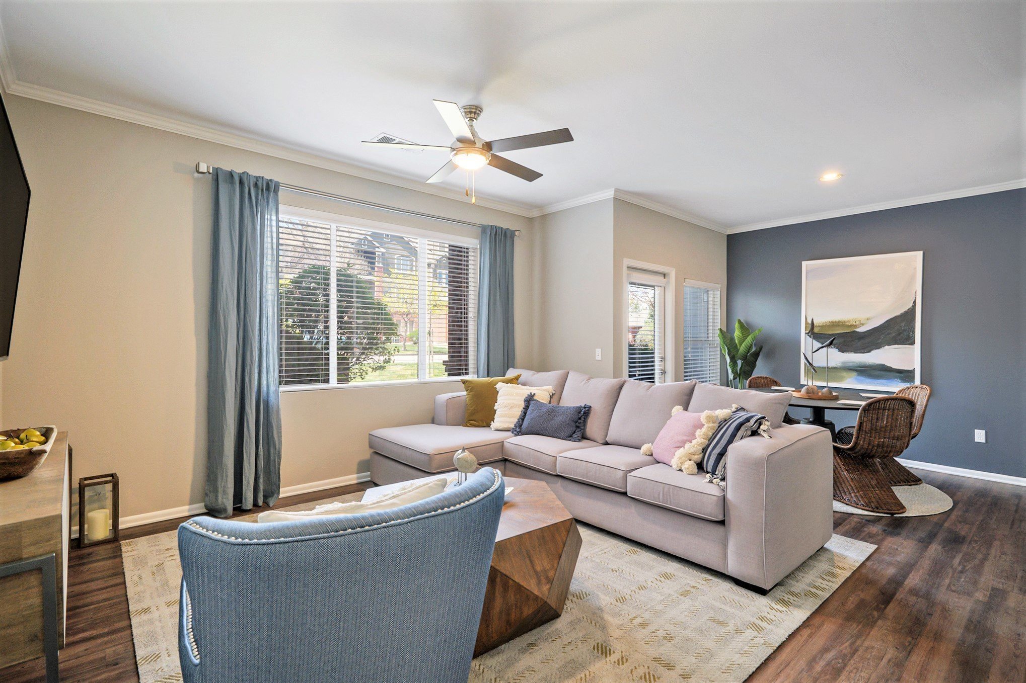 A living room with a couch, chair, and a ceiling fan.