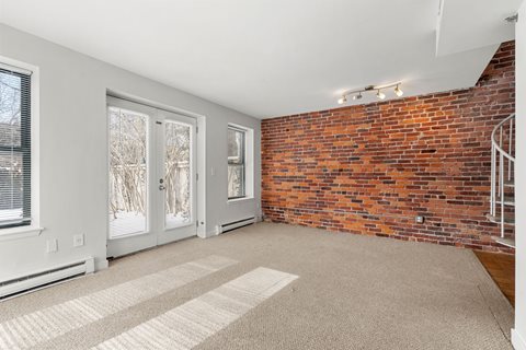 A room with a brick wall and a carpeted floor.