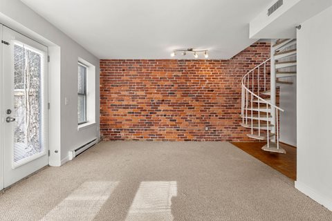 A room with a red brick wall and a white door.