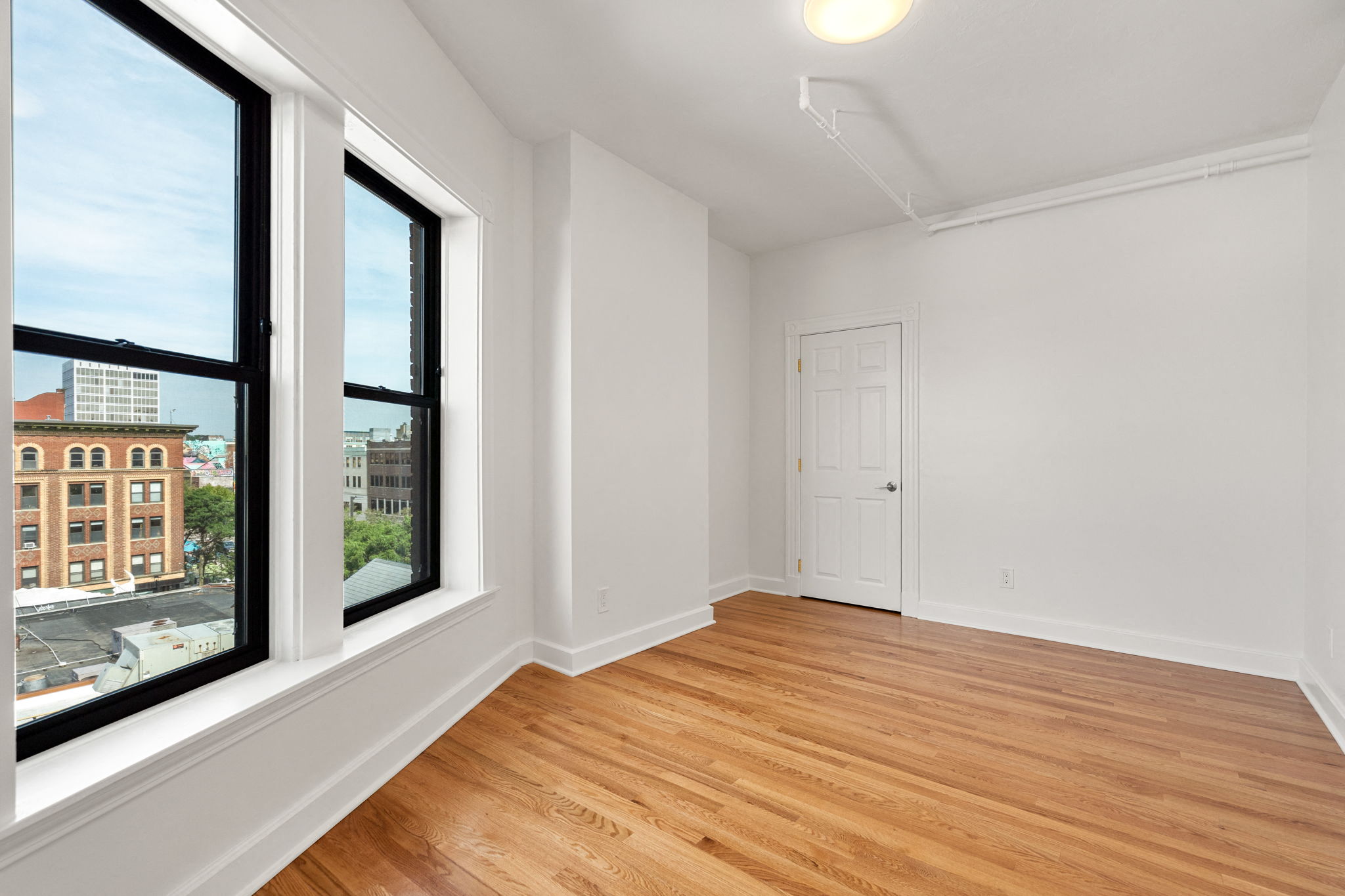 440-7 an empty living room with two large windows and a door