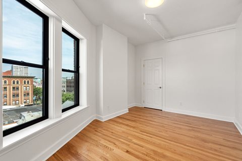 440-7 an empty living room with two large windows and a door