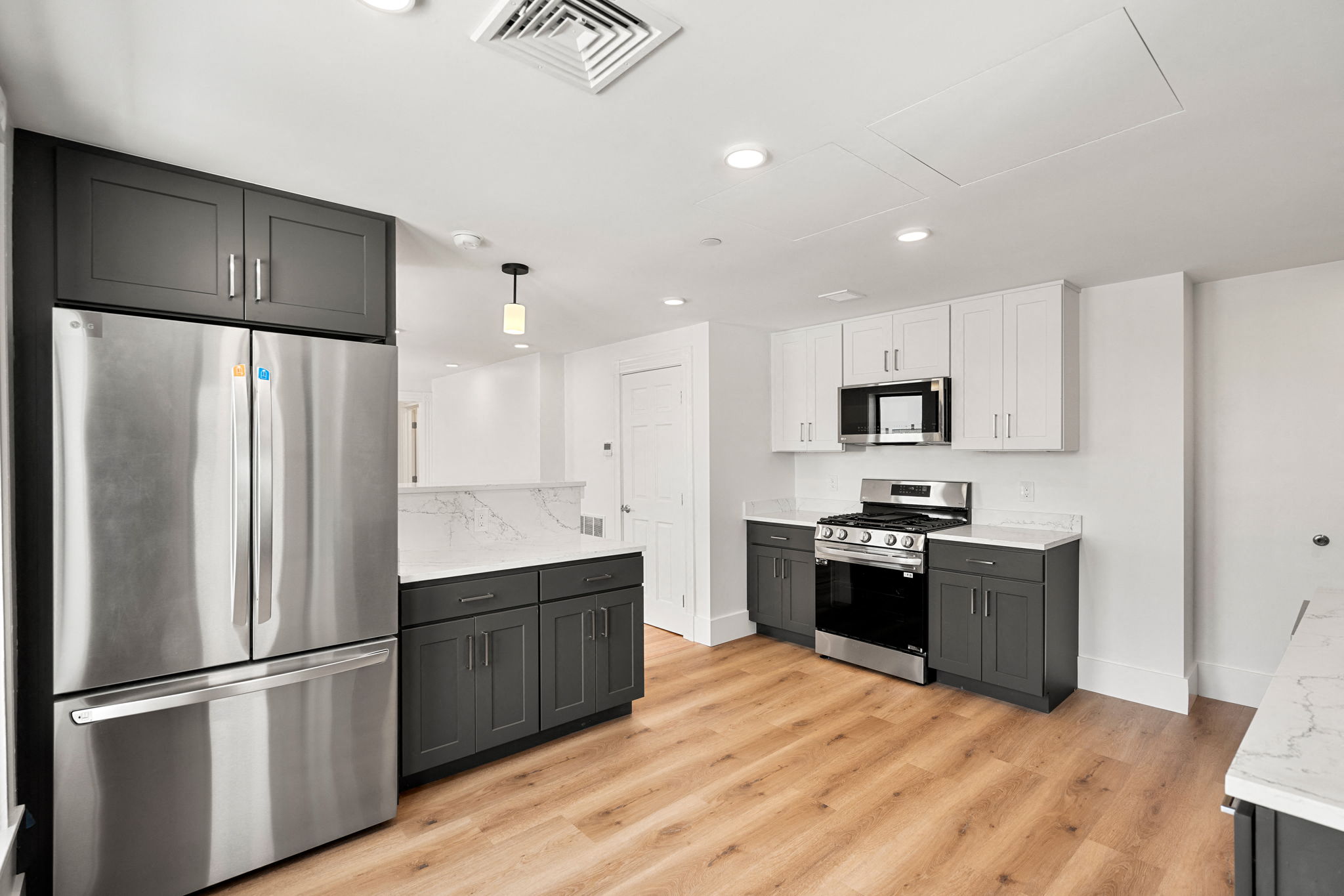 440-7 a renovated kitchen with stainless steel appliances and white cabinets