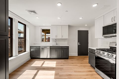 a kitchen with white cabinets and stainless steel appliances