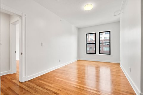440-7 an empty living room with wood floors and a window