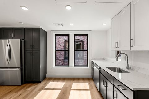 a kitchen with black and white cabinets and a window