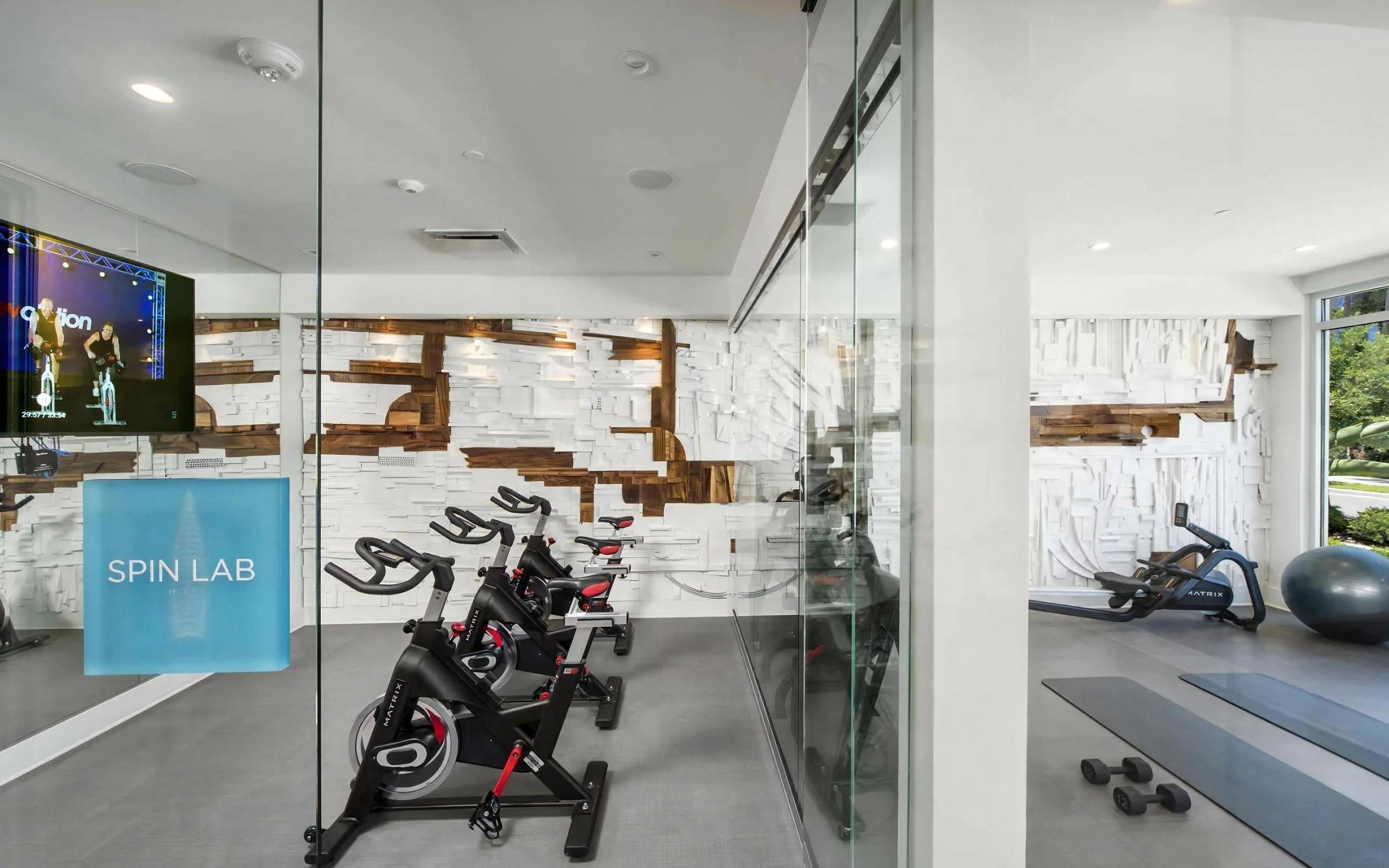 Modern Wellness Space with Indoor Cycling Equipment and Yoga Zone
