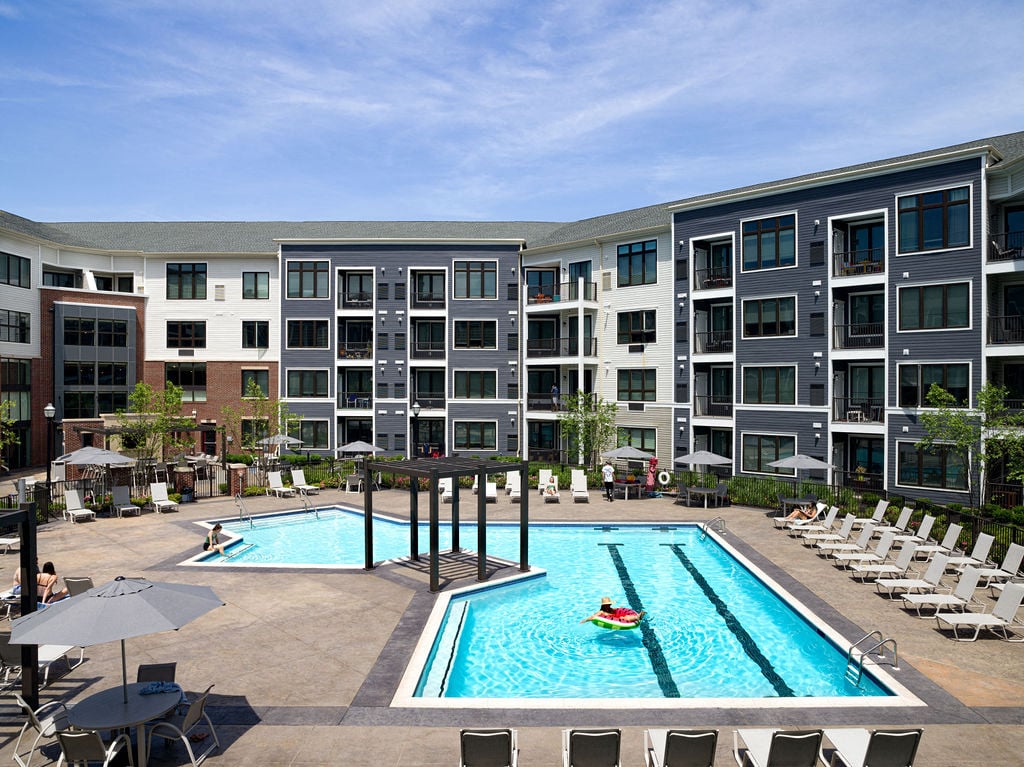 A large swimming pool in front of apartment buildings