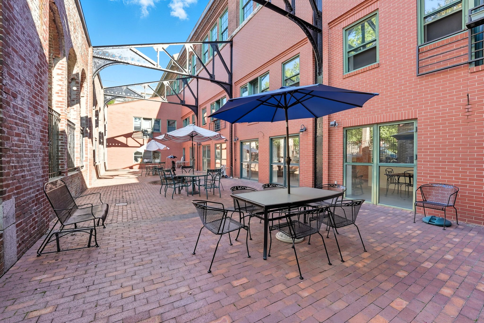 A patio with a table and chairs and an umbrella.