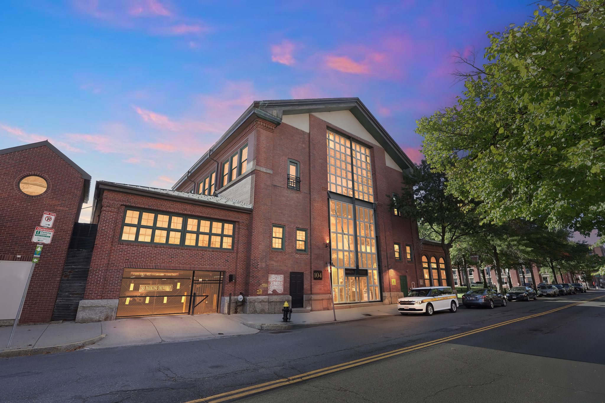 A red brick building with a white van parked in front.