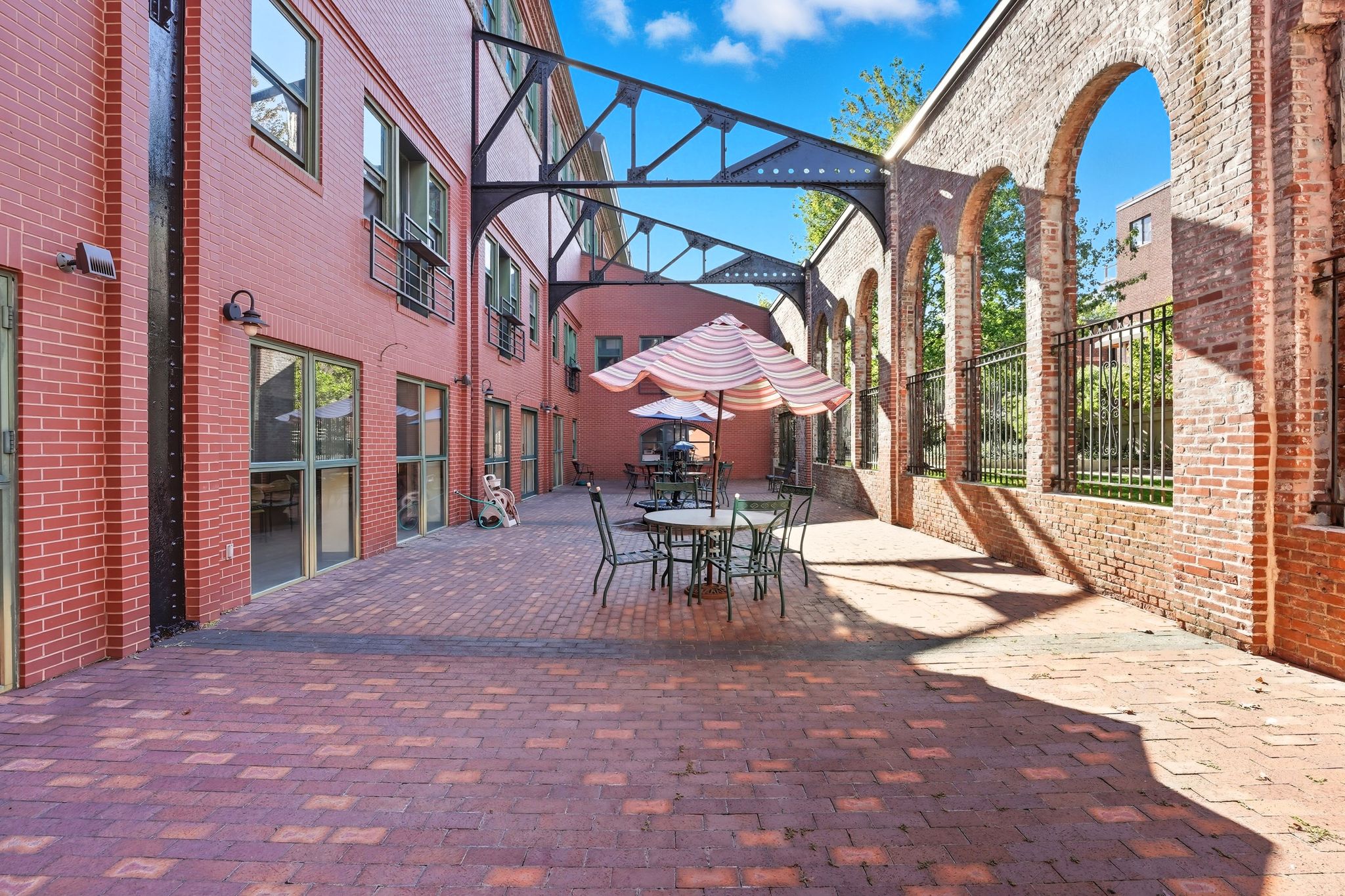 A patio with a table and chairs is surrounded by brick buildings.