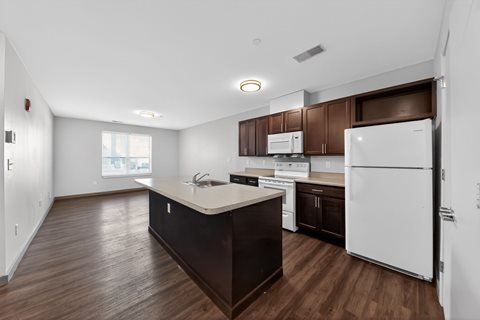 A kitchen with white appliances and brown cabinets.