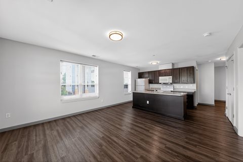 A kitchen with a wooden floor and a window.