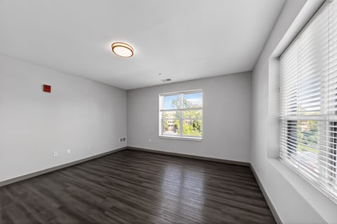 A room with a window showing a view of a building outside.