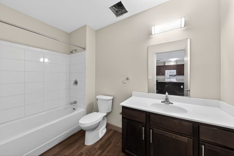 A white toilet sits next to a white sink in a bathroom.