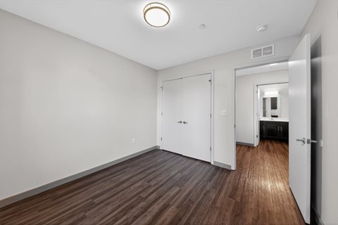 A room with a white door and a brown floor.