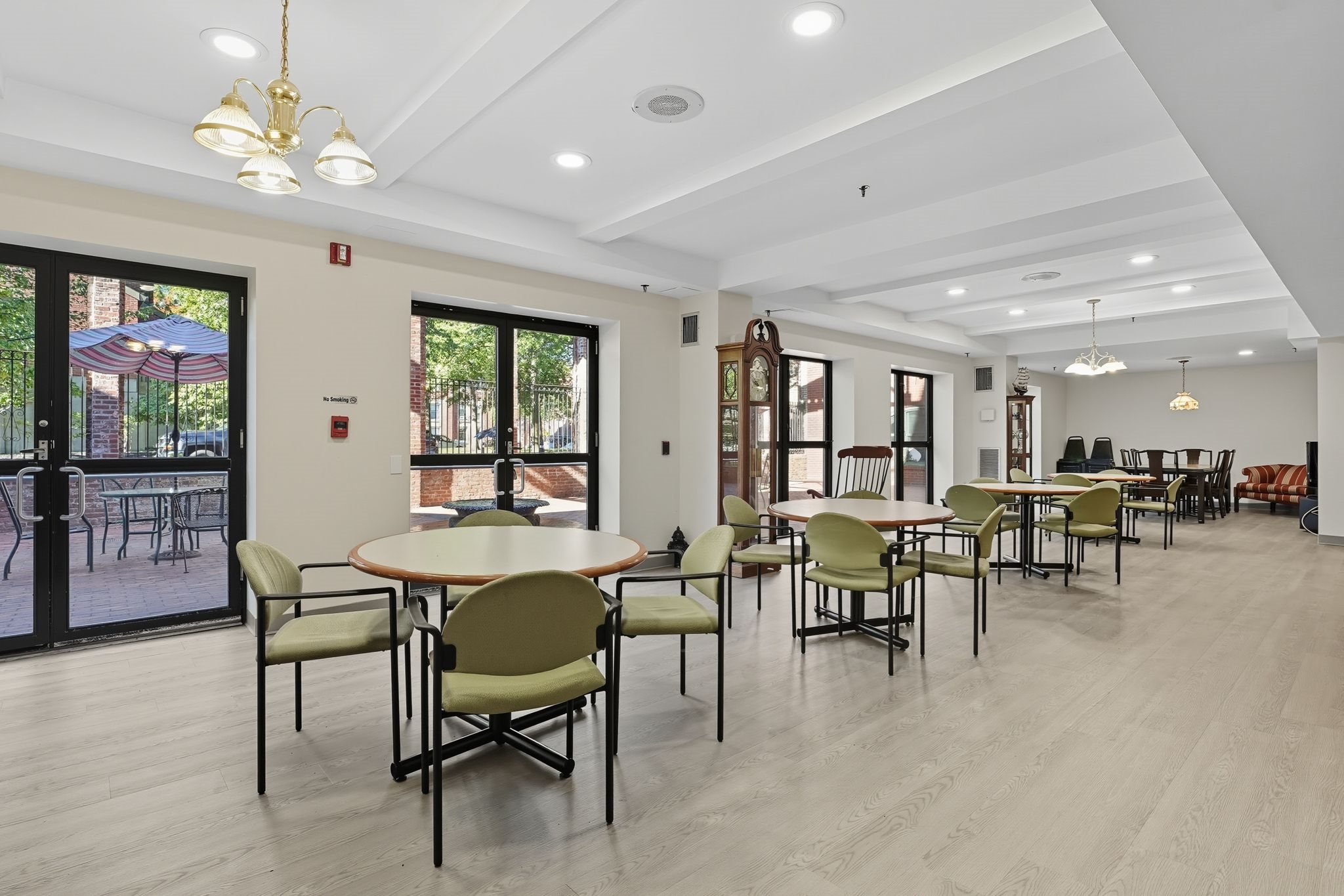 A large room with tables and chairs and a fire extinguisher on the wall.