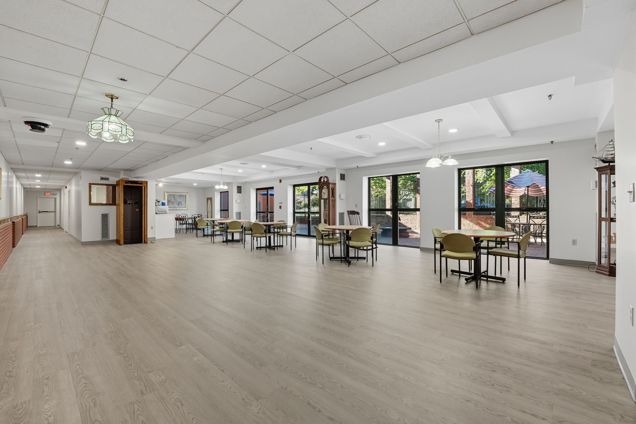 A spacious room with wooden floors and a long table with chairs.