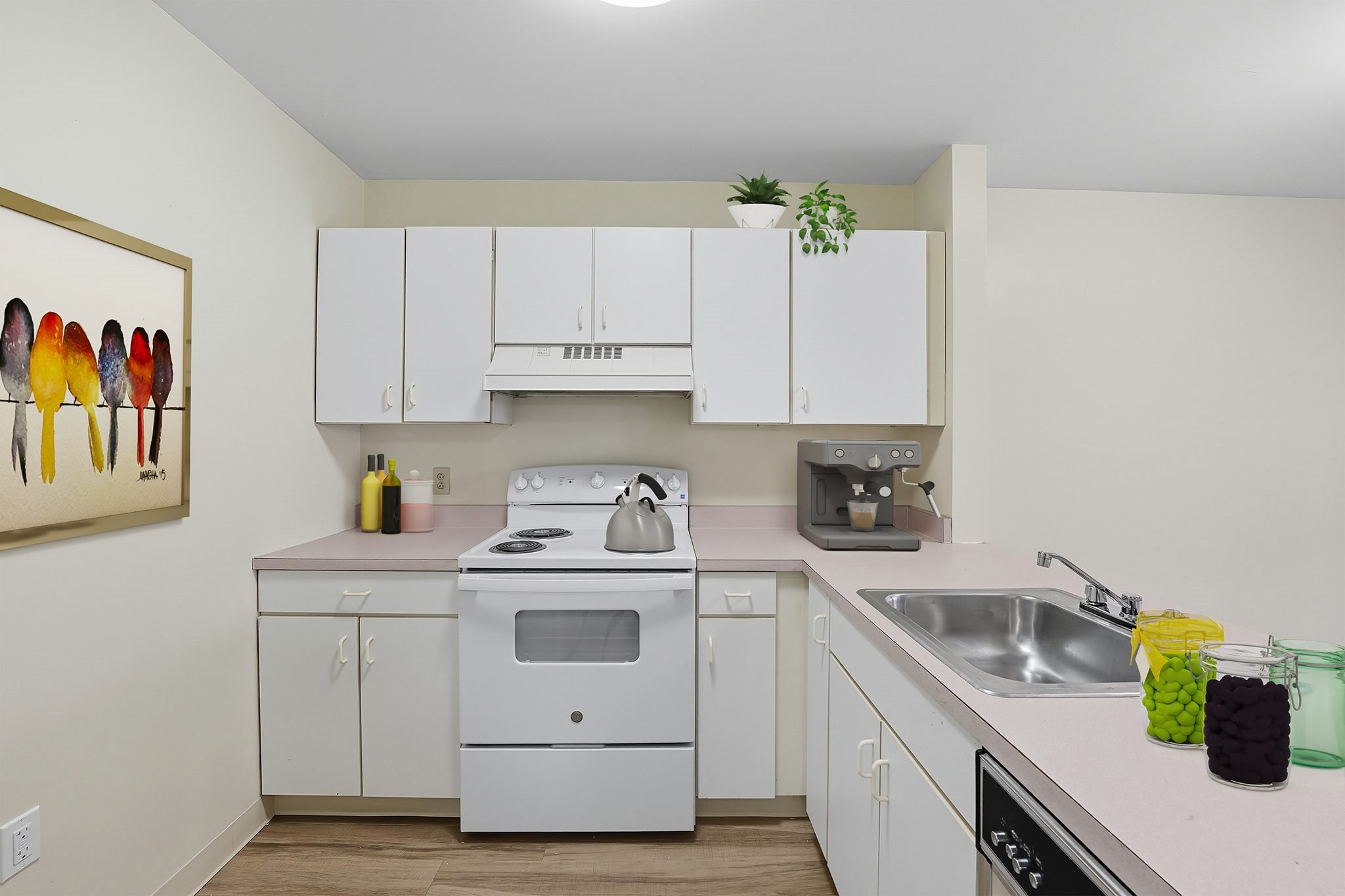 A white kitchen with a white stove and white cabinets.