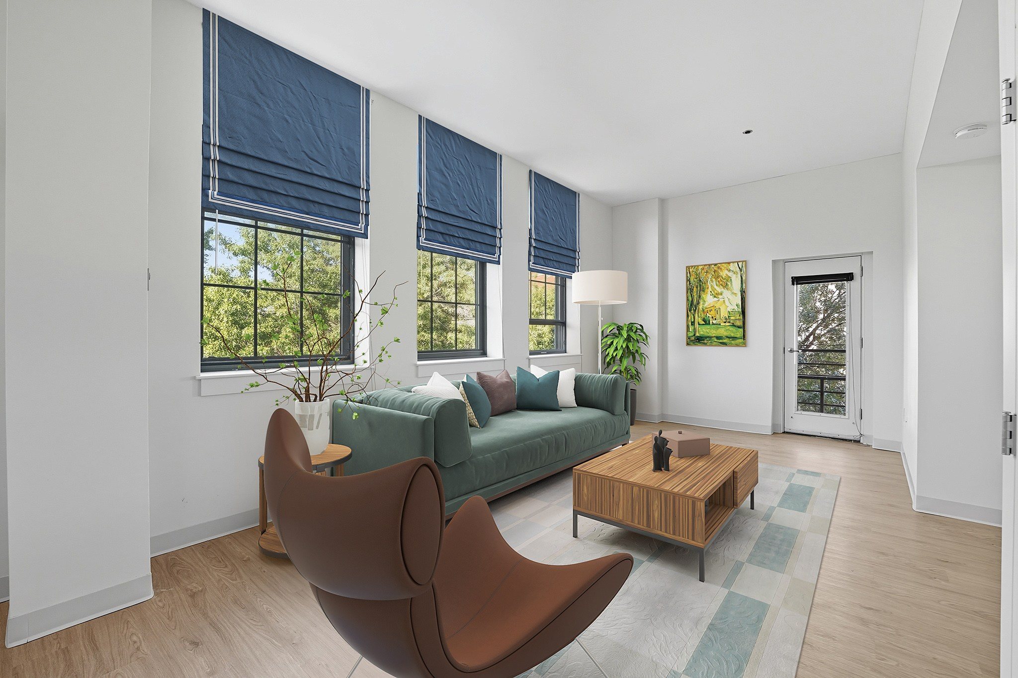 A living room with a green couch, a brown chair, and a wooden coffee table.