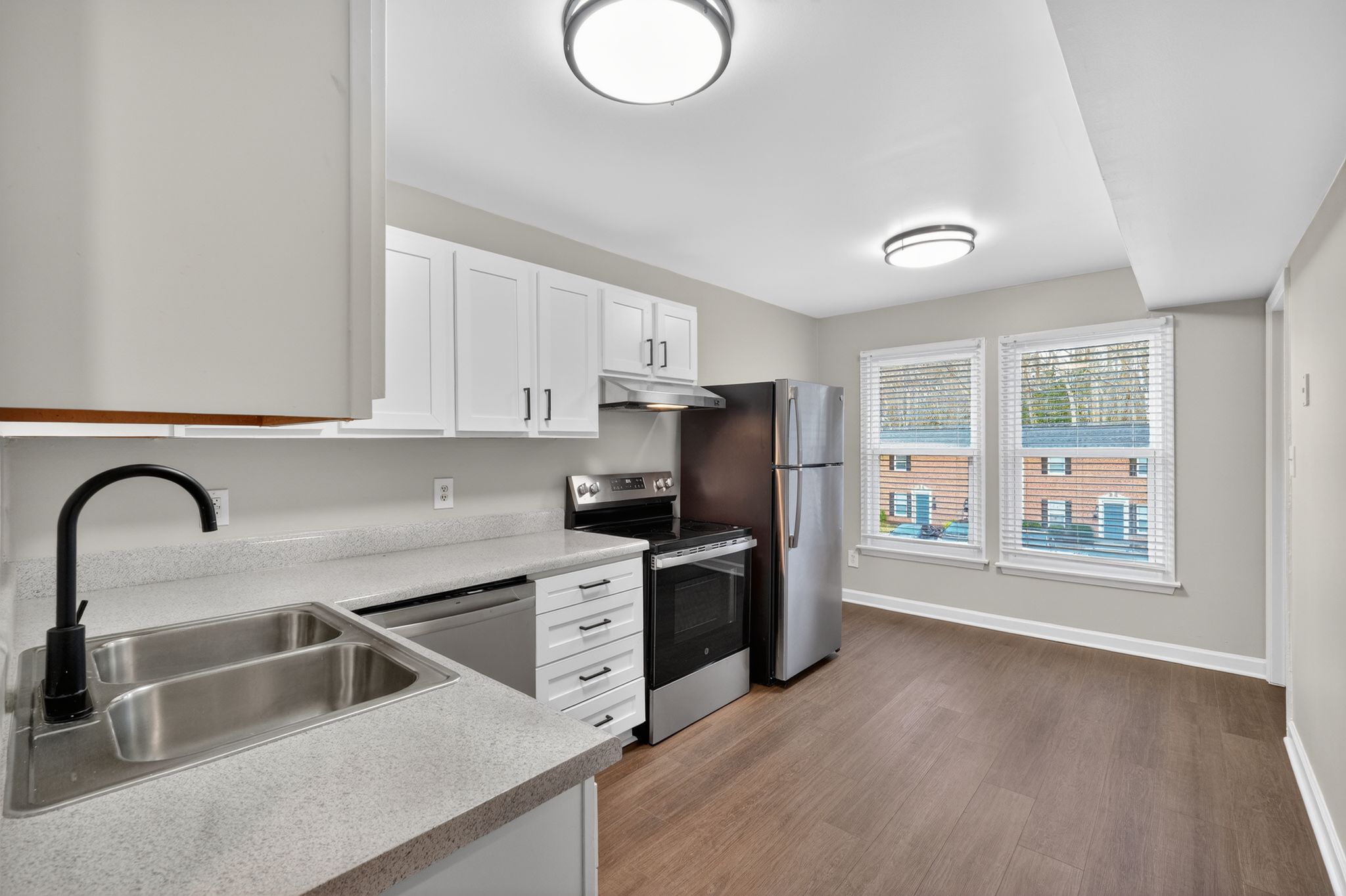 A kitchen with a stainless steel refrigerator, dishwasher, and oven.